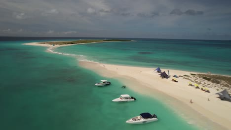 Archipiélago-De-Los-Roques-En-Venezuela-Con-Aguas-Cristalinas-De-Color-Turquesa,-Playa-De-Arena-Blanca-Y-Barcos-Amarrados,-Vista-Aérea