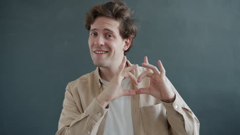 hombre haciendo forma de corazón con las manos