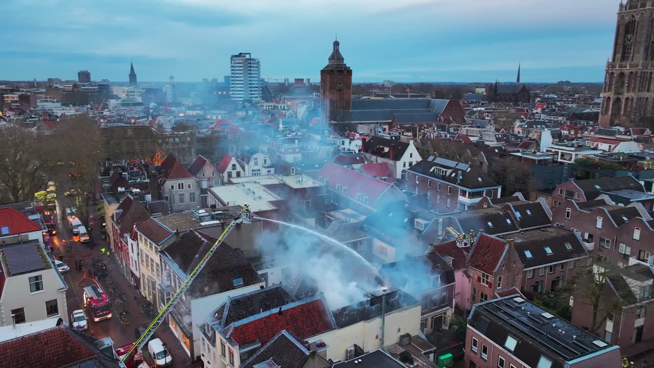 ユトレヒトの火災とガス爆発、煙が立ち込める市街中心部、オランダ、消防隊のクレーンから消防士が消火活動中、歴史的中心部上空の空撮ドローン映像。