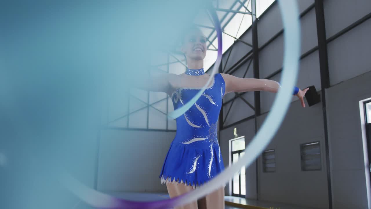 여자 체조 선수 가 스포츠 홀 에서 공연 하고 있다