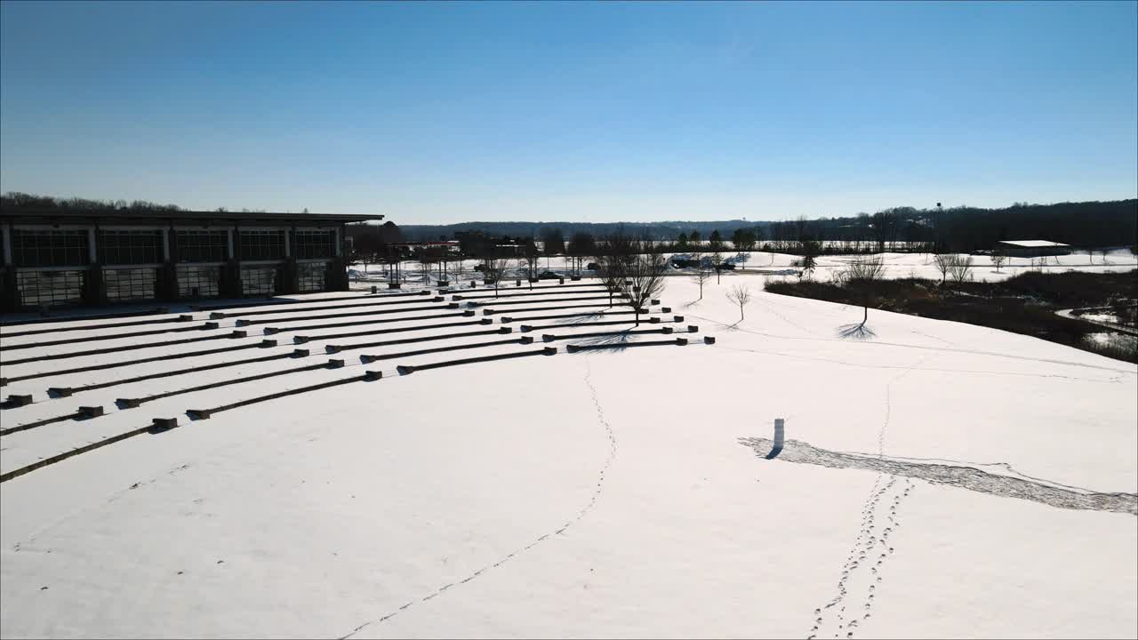 volando hacia un anfiteatro al aire libre congelado en el parque después de una tormenta de nieve