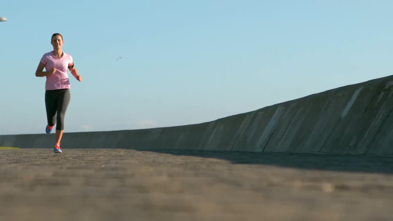una mujer deportiva sonriente haciendo un trote