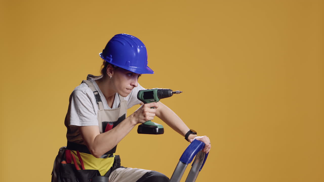 Confident constructor using electric power drill to screw nails