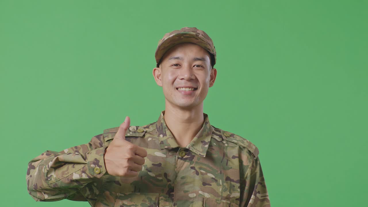 Close Up Of Asian Man Soldier Smiling And Showing Thumbs Up Gesture While Standing In The Green Screen Background Studio