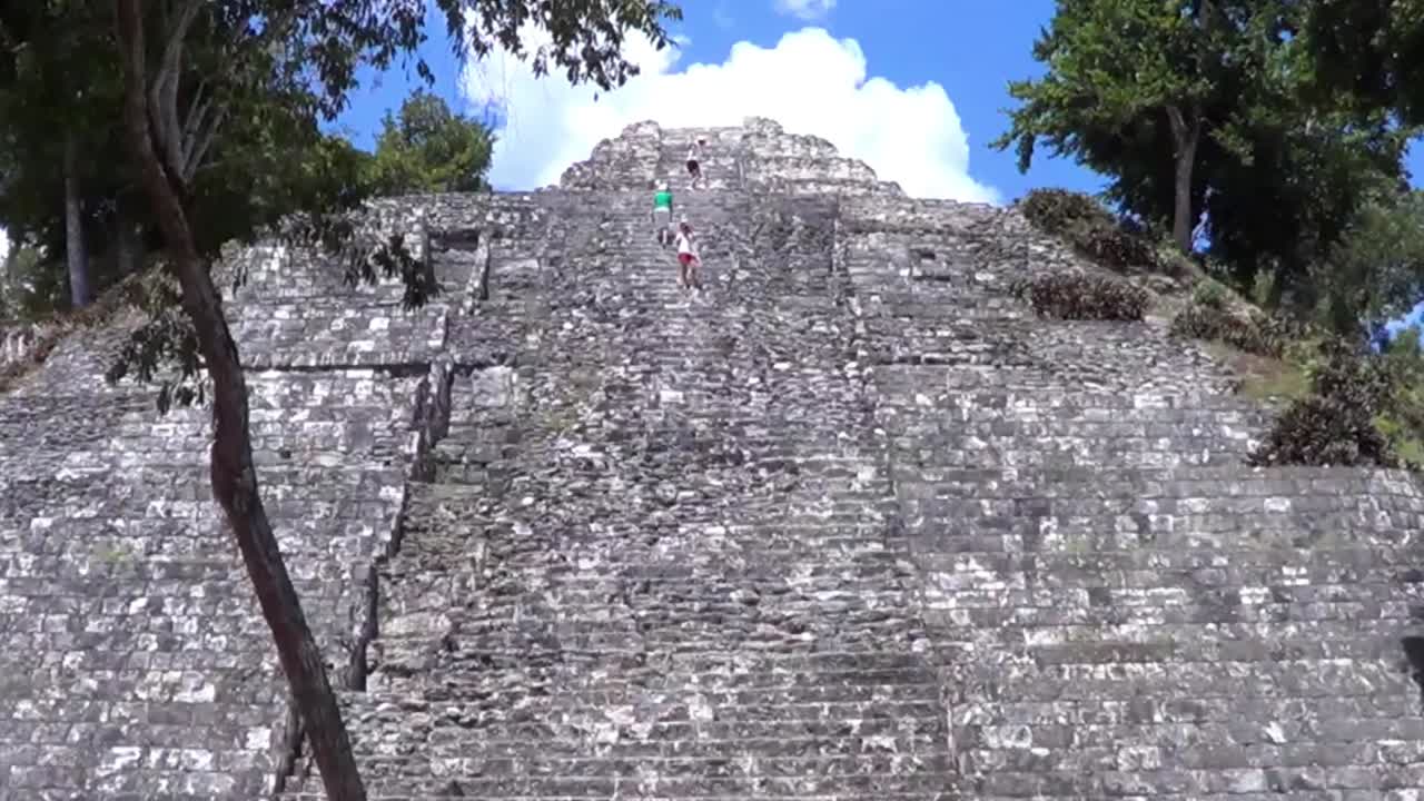 Tourist climbing the Temple 216 in the East Acropolis at Yaxha, Guatemala