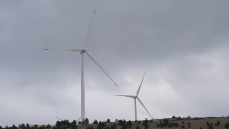 a large wind turbine plant. sustainable and renewable green energy from the wind. turbines arranged on a mountain plateau. windy weather before the storm.