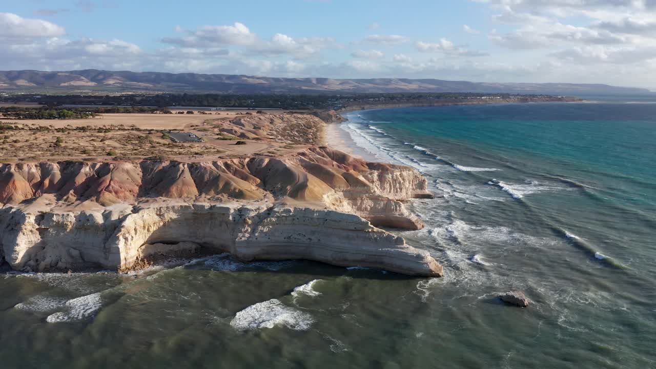 Drone reverse shot reveals Blanche Point cliffs with people sitting on edge, Port Willunga, Adelaide, South Australia