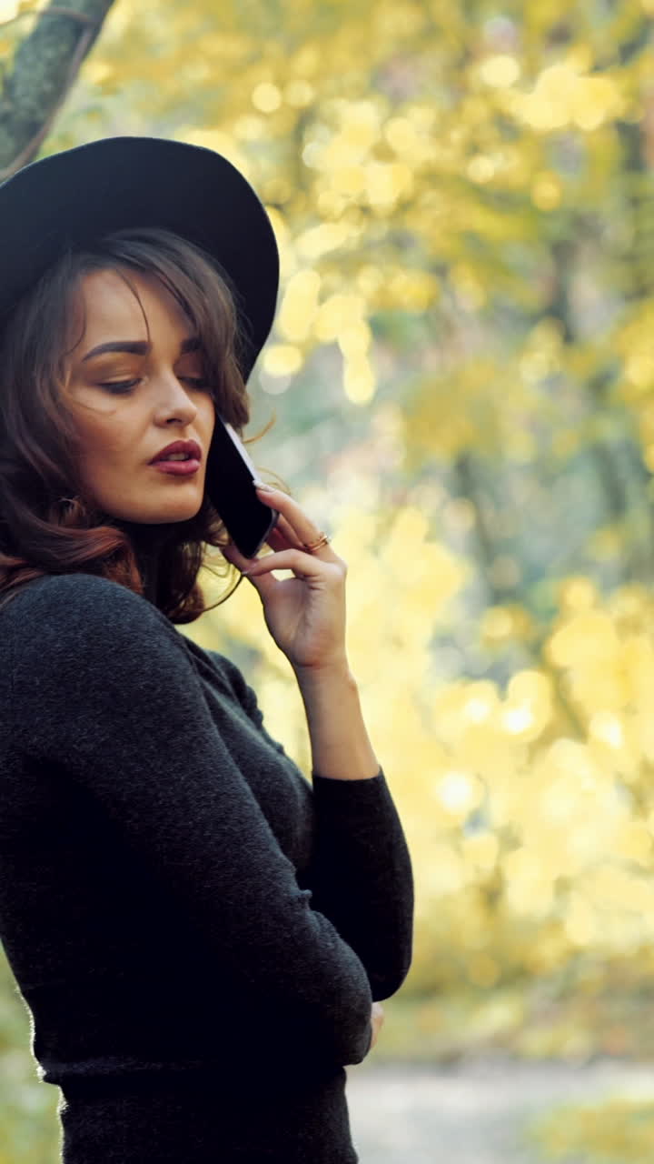 Woman posing in park. Happy young woman posing in autumn park Vertical video