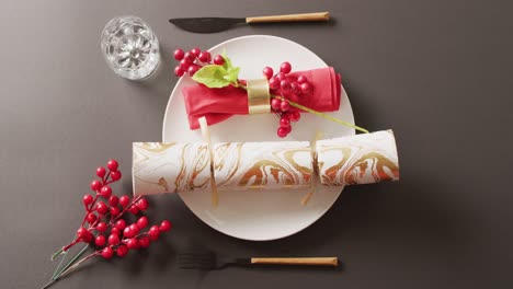 Video-of-christmas-place-setting-with-christmas-cracker-on-grey-background