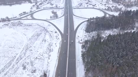 aerial shooting from flying drone car moving on winter highway intersection