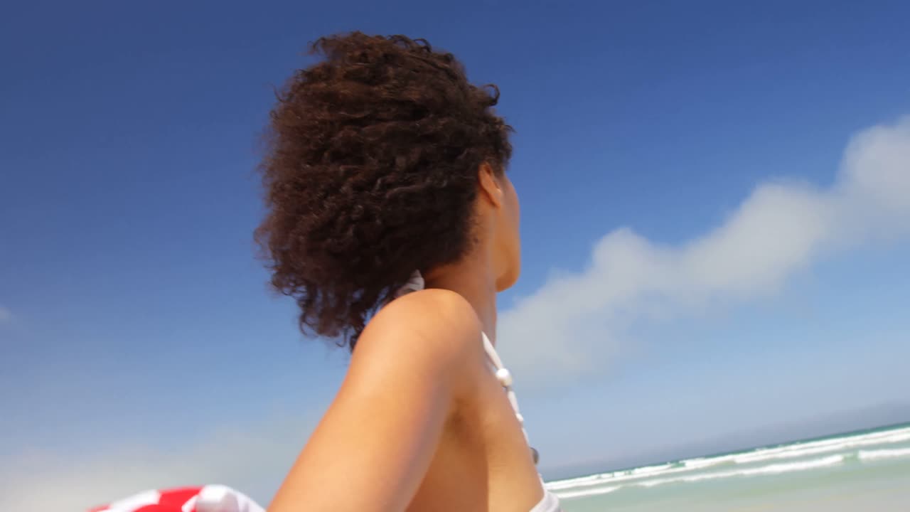 해변 4k에서 미국  ⁇ 발을 흔들고 바 ⁇ 가에 서 있는 여자