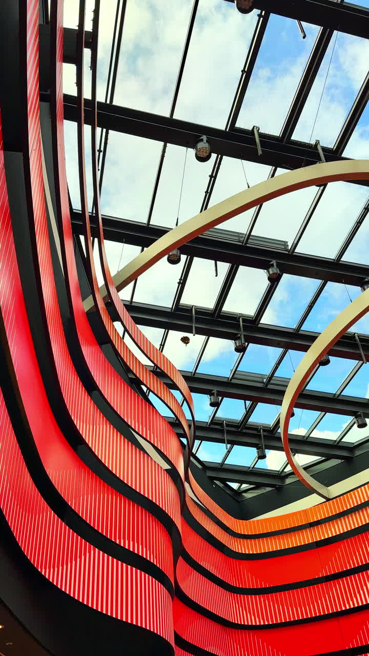 Teto de vidro transparente moderno com detalhes metálicos. Cobertura de um shopping center com amplas janelas de vidro. Vista do céu através do teto transparente.