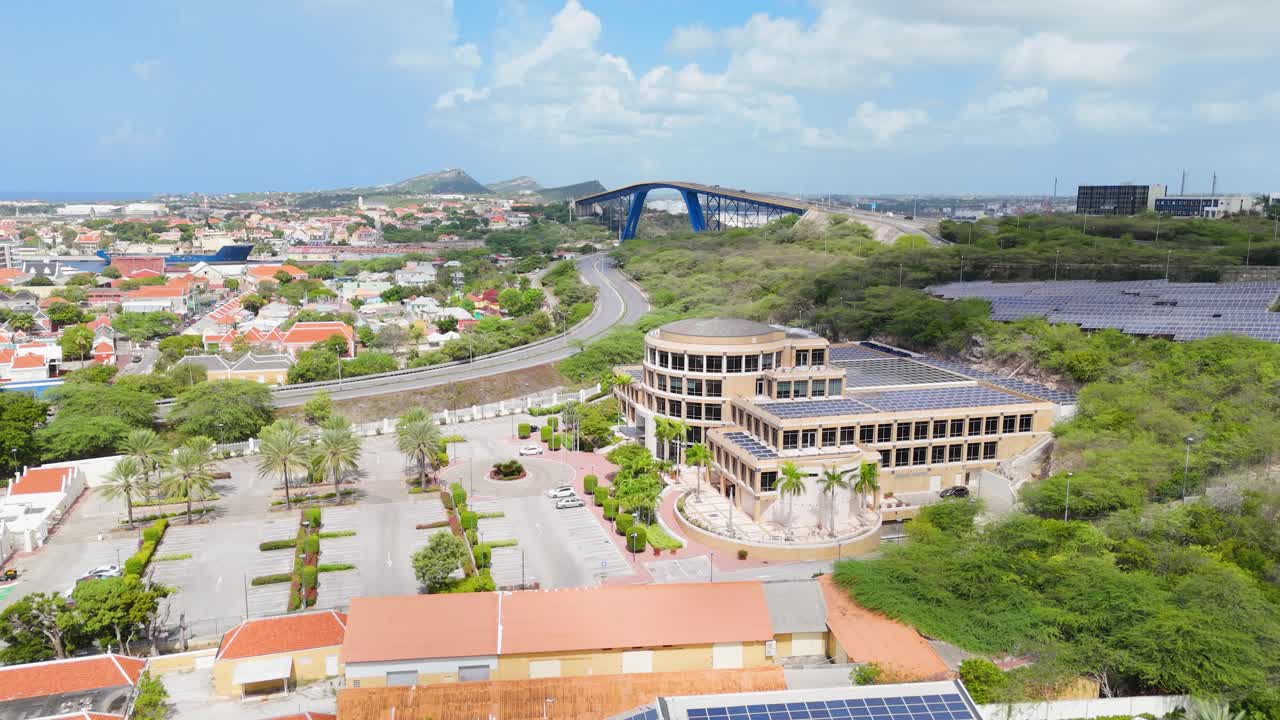 Drone dolly over building with solar panels on roofs in a Caribbean island, emphasizing sustainable energy
