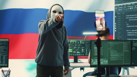 anonymous person with mask asks for ransom in russian governmental hacking room