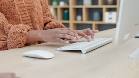 woman typing on computer at desk