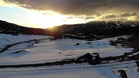 Toma-De-Drones-De-Una-Increíble-Puesta-De-Sol-Detrás-De-Las-Montañas-Durante-El-Invierno