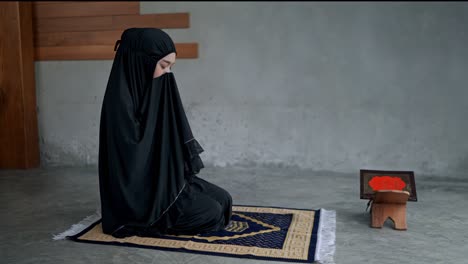 young muslim woman praying at home