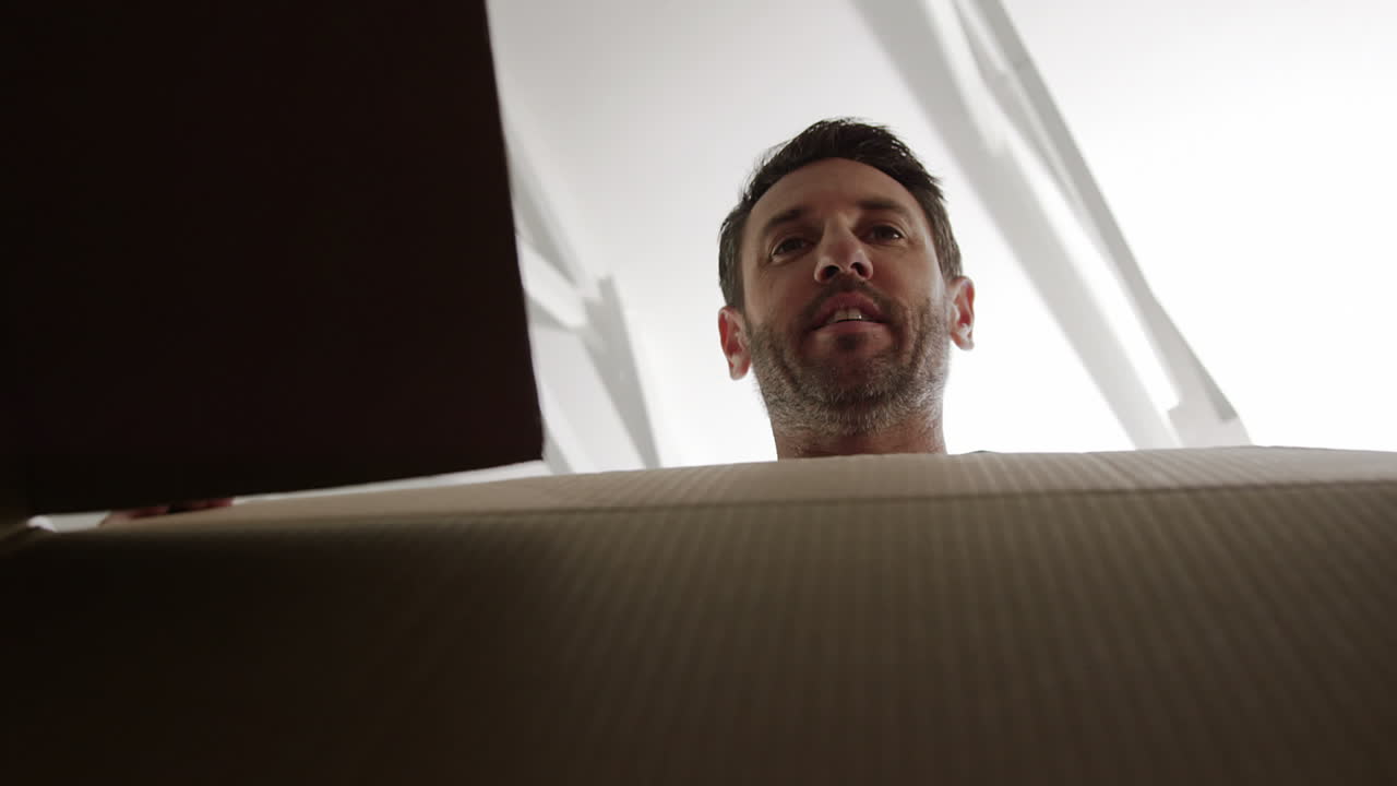 un hombre abriendo una caja de cartón