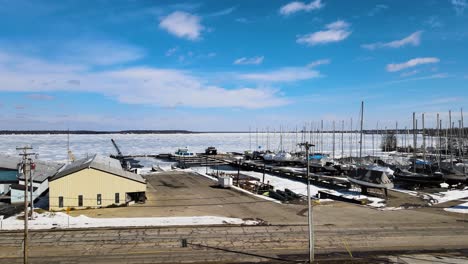 drone elevándose hacia arriba sobre el lago muskegon cubierto de hielo