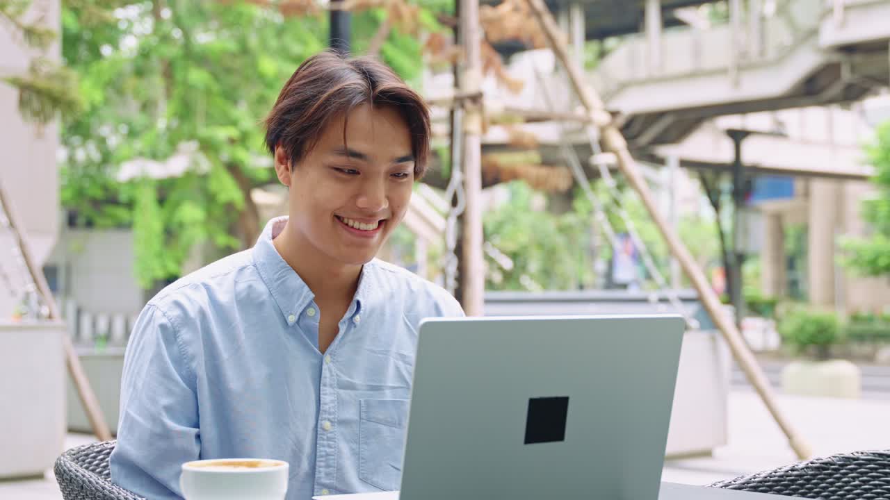 Man working on laptop at outdoor cafe