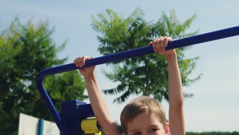 a little boy does sports on the playground 03