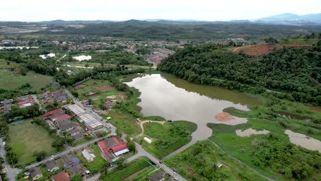 Aerial-flying-towards-lake-reflecting-cloudy-sky-at-Serendah