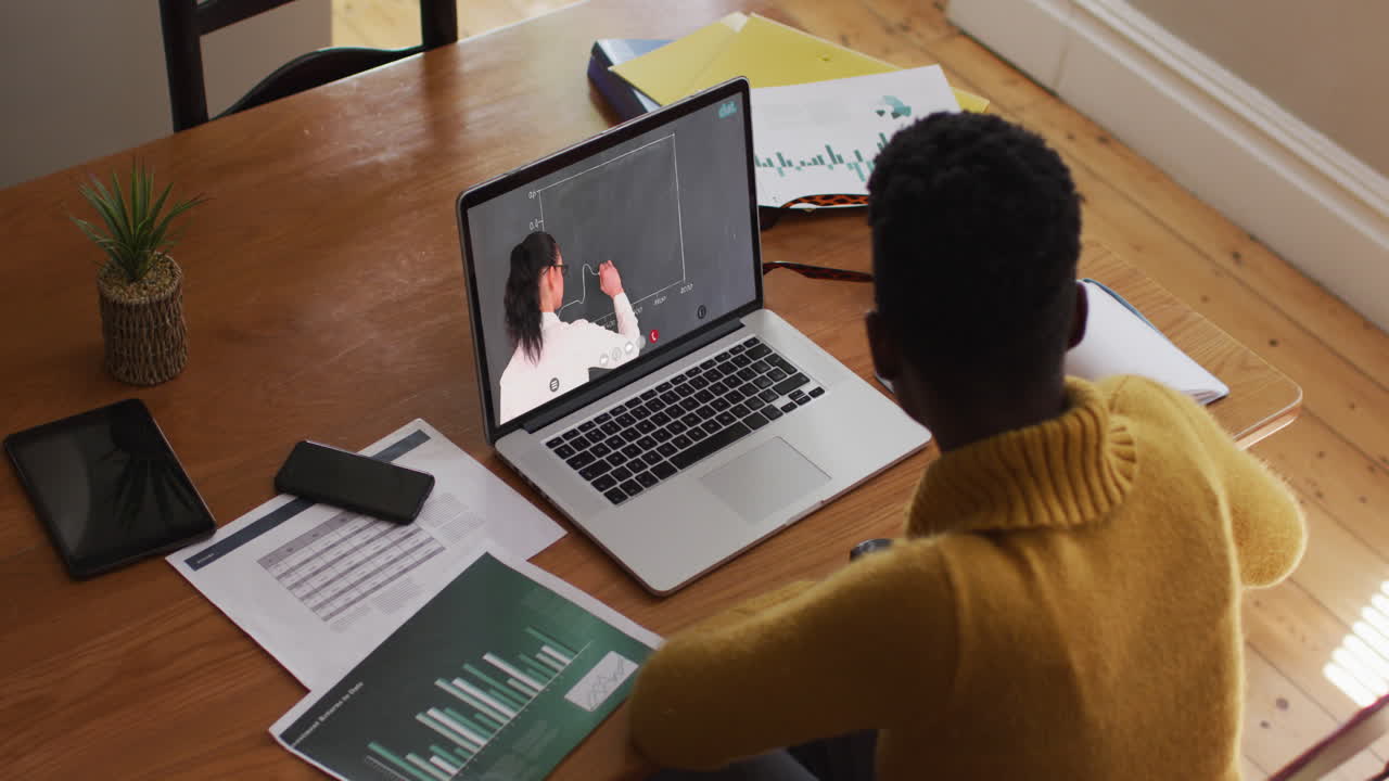 African american female student using laptop on video call with female teacher