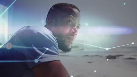 red brillante de conexiones contra el hombre afroamericano disfrutando de la vista en la playa