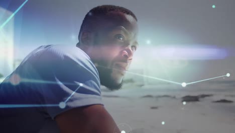 glowing network of connections against african american man enjoying the view at the beach