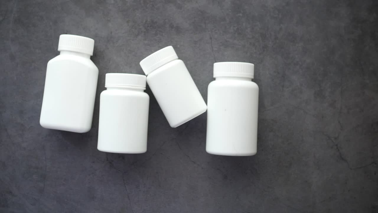 botellas de medicamentos blancas en superficie gris