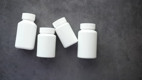 blank white medicine bottles on gray surface