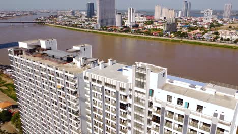 highrise residential apartment building construction on tonle sap river, phnom penh city, drone shot