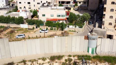 aerial view of a security separation wall and guard tower in a residential area