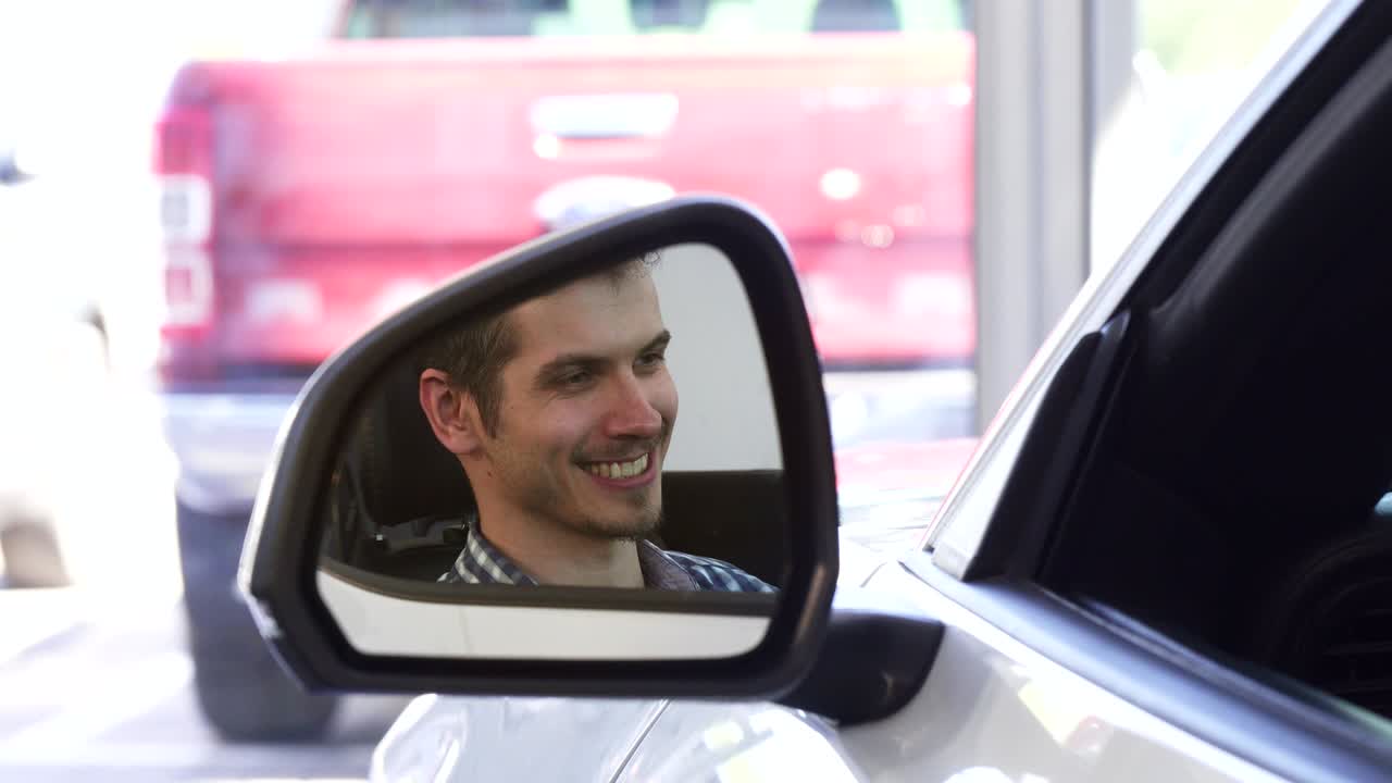 cerca de un espejo lateral de un coche, feliz conductor masculino sonriendo