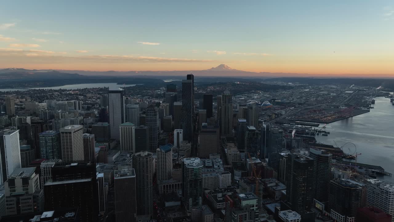 vista panorámica del distrito del centro y el paseo marítimo de seattle con el horizonte naranja y mt rainer