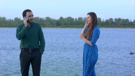 man and woman with cell phones talking