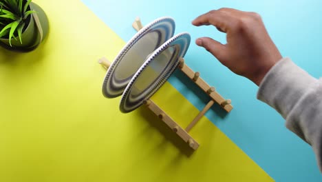 hand taking a plate from a wooden rack on a blue and yellow background