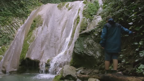 boy at waterfall in forest