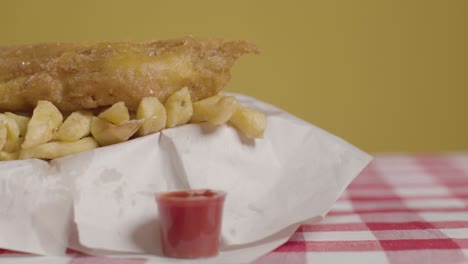 Close-Up-Studio-Shot-Of-Traditional-British-Takeaway-Meal-Of-Fish-And-Chips-With-Vinegar-1