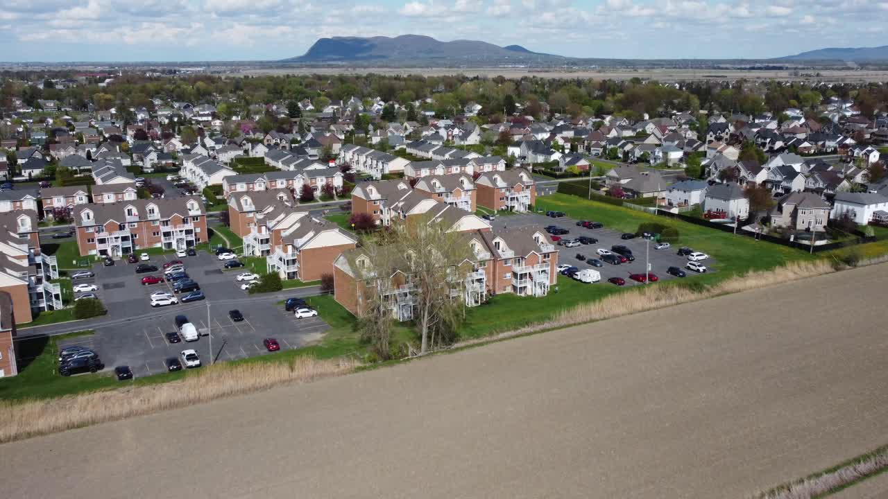 Establishing aerial of real estate suburban houses and apartments with mountain view