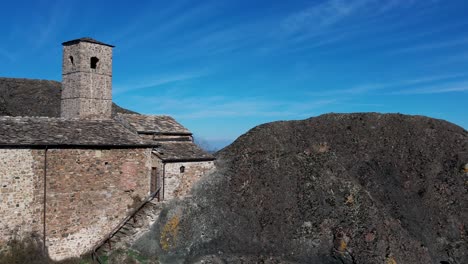 Europe,-Italy,-Travo-,-Drone-failure-aerial-footage-of-Pietra-Perduca,-volcanic-rock,-church-set-at-top-stone-immersed-in-countryside-landscape,-cultivated-land-in-Val-Trebbia-Bobbio