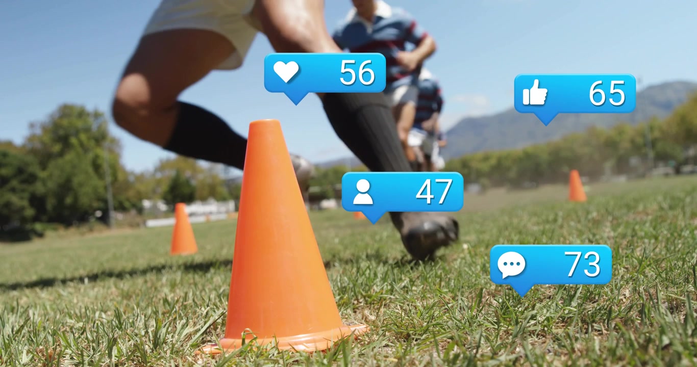 Giocatori di rugby maschi che iniziano un esercizio e scattano oltre un cono in primo piano mentre i "mi piace" animati aumentano