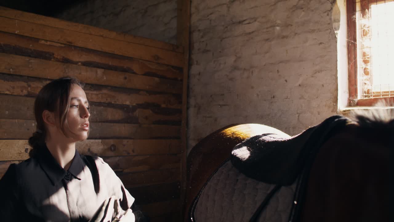 mujer arreglando un caballo en un establo