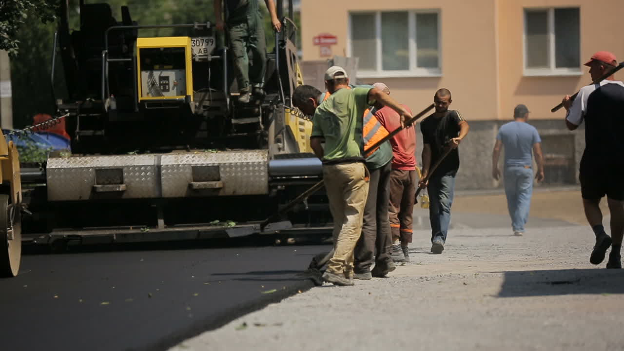 VINNITSA, UKRAINE - JULY 2017: Men working at the road construction