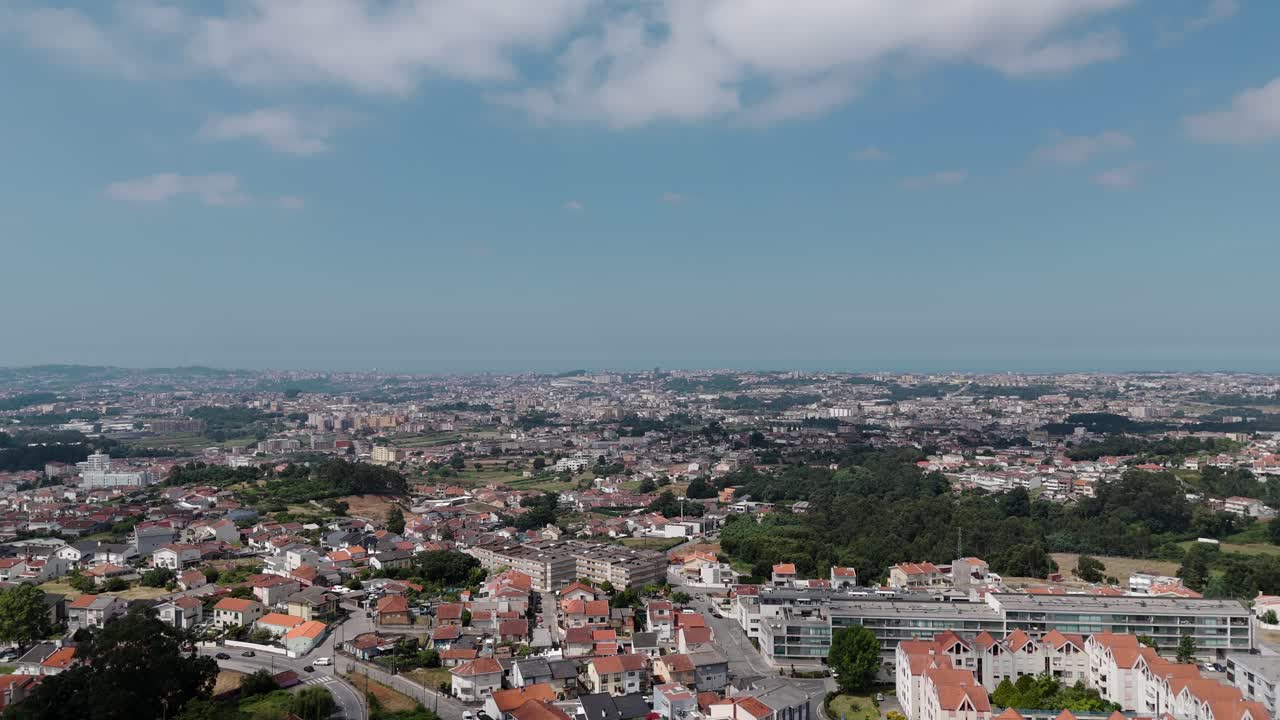 aerial wide shot of Porto Portugal showing dense urban landscape under soft blue skies