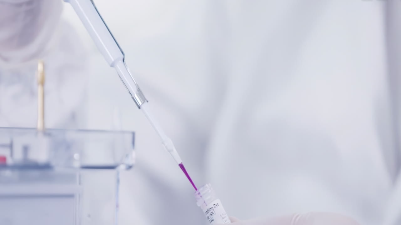 Research scientists work in a cleanroom environmental conduct pipette Dispensing pink Liquid into Microplate Scientific Research Laboratory Technology Equipment Precise Accurate High Quality