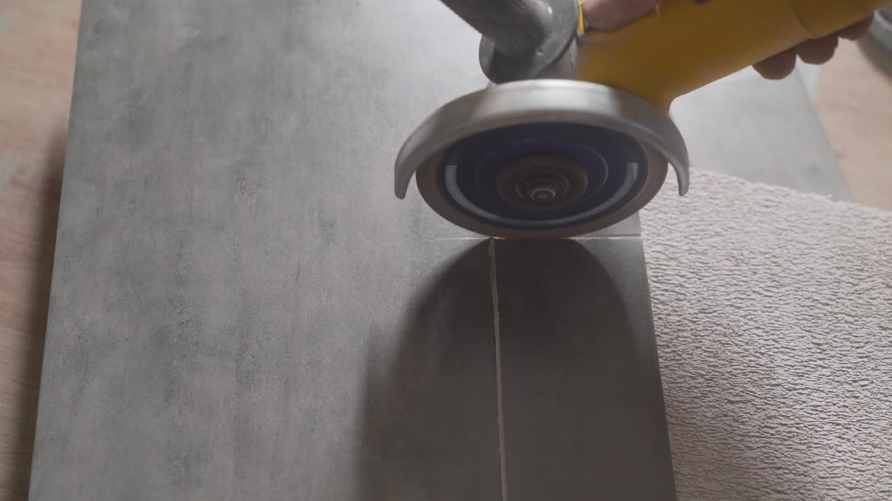 Industry close up professional hand man worker cutting tile marble ceramic with circular saw electric power tool in construction site interior. A worker is sawing ceramic tiles.