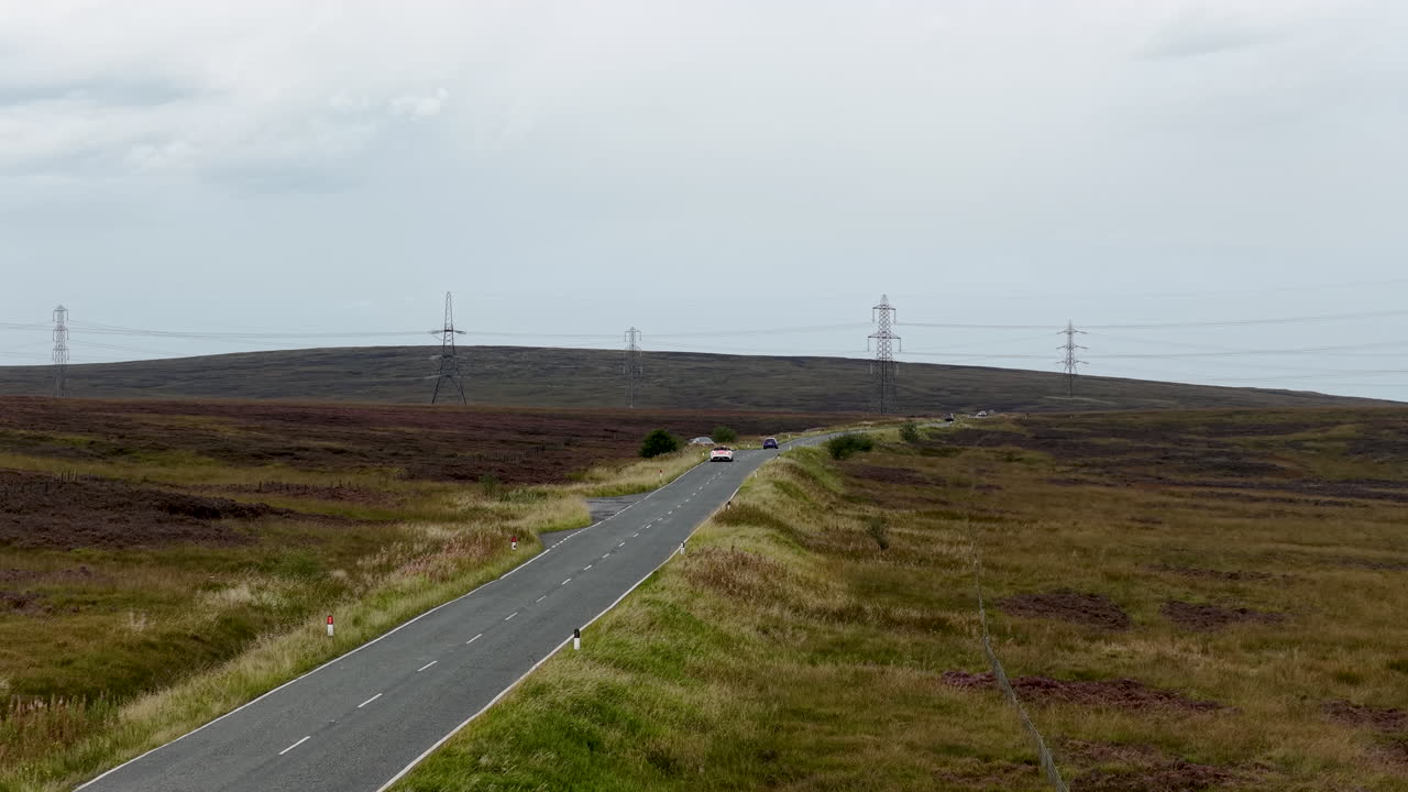 Following aerial drone footage of a white Jaguar F‑Type convertible speeding along a rural West Yorkshire road, surrounded by fields and countryside scenery