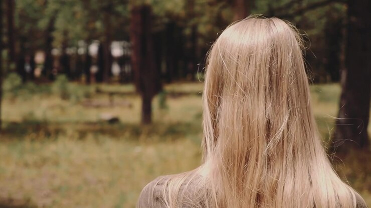 Jonge vrouw lopend en staand in een grasrijk bos