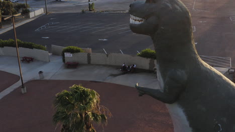 Luftaufnahme-Einer-Drohne,-Die-Im-Cabazon-Dinosaurier-Themenpark-In-Der-Nähe-Von-Palm-Springs-In-Kalifornien,-USA,-Aufsteigt-Und-Sich-Um-Einen-Riesigen-Tyrannosaurus-Rex-Dreht